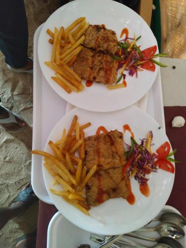 two plates of food on a tray with french fries at Loveshore Marari in Mararikulam