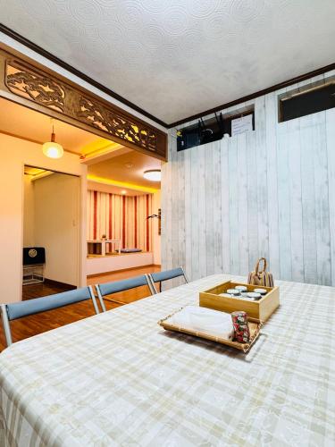 a room with a bed with a box on it at 晶 距离车站步行5分钟 关西机场难波心斋桥直达 5 bedroom最多可住13人 超大客厅大电视有Netflix in Osaka