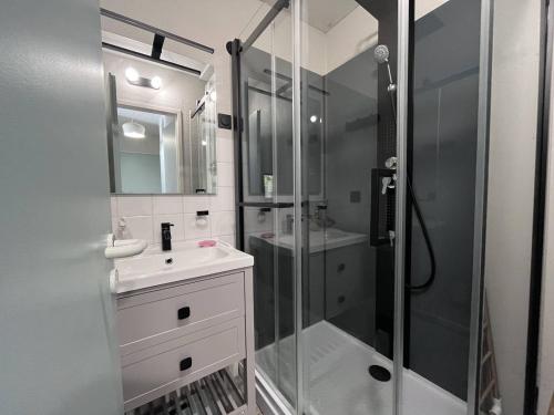 une salle de bain blanche avec une douche et un lavabo dans l'établissement Duplex charmant à Cauterets, proche commerces et téléphérique - FR-1-812-82, à Cauterets