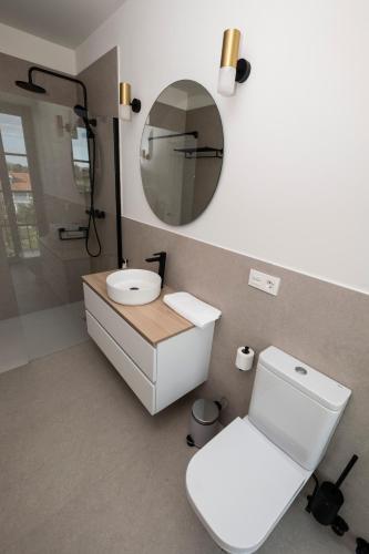 a bathroom with a white toilet and a mirror at Indiano House Apartments, Muros de Nalón, 5km Cudillero in Muros de Nalón