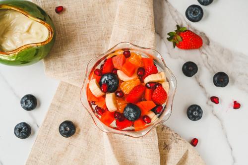 uma fruteira com mirtilos e morangos sobre uma mesa em Baymaas LakeHouse em Ernakulam