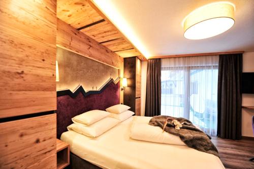 a bedroom with a bed with a dog laying on it at Hotel Garni Bellevue in Ischgl