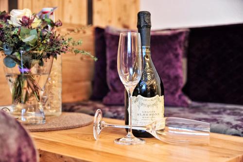 a bottle of wine sitting on a table with glasses at Hotel Garni Bellevue in Ischgl