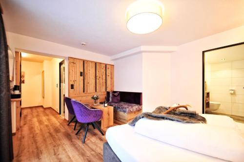 a bedroom with a bed and a desk and a chair at Hotel Garni Bellevue in Ischgl