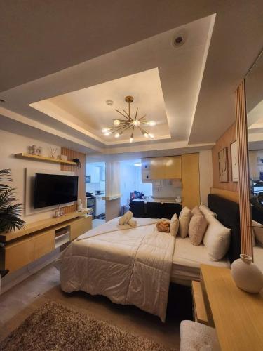 a large bedroom with a large bed and a flat screen tv at Side Wall Condo in San Fernando