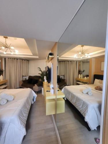 a hotel room with two beds and a mirror at Side Wall Condo in San Fernando