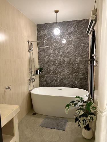 a bathroom with a bath tub and a plant at Tuator Villa Kohlarn in Ko Larn