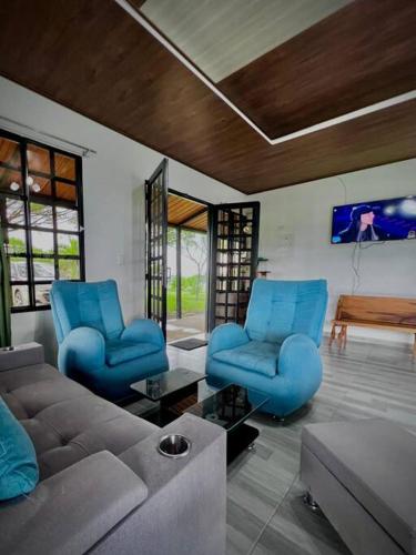 a living room with blue chairs and a couch at Cabaña Campestre in Buenavista