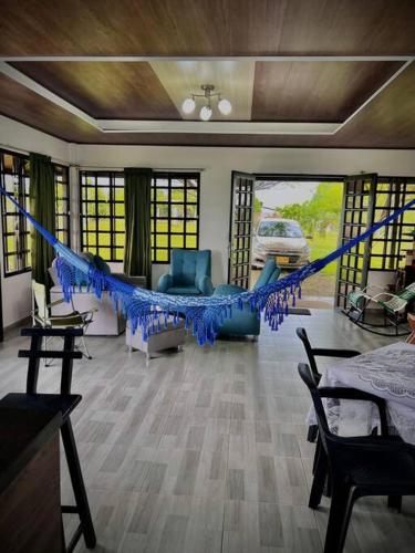 a living room with a blue hammock in it at Cabaña Campestre in Buenavista