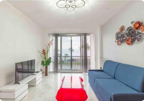 un salon avec un canapé bleu et une table dans l'établissement Nice promenade des anglais vue mer, à Nice