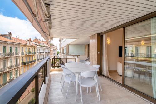 un balcon avec une table blanche et des chaises dessus dans l'établissement 1958 - Luxury apartment Gray Albion - 100m Palais, à Cannes