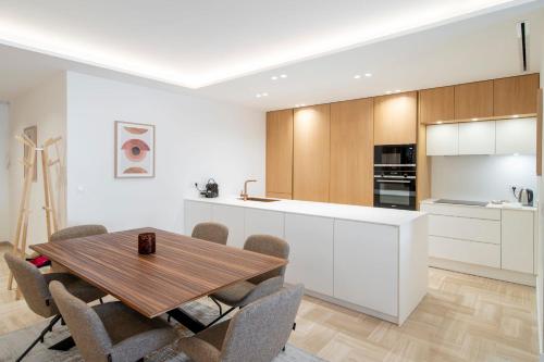 une cuisine et une salle à manger avec une table et des chaises en bois dans l'établissement 1958 - Luxury apartment Gray Albion - 100m Palais, à Cannes