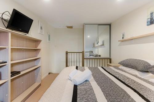 a bedroom with a bed and a flat screen tv at Randwick City Lodge 2 in Sydney