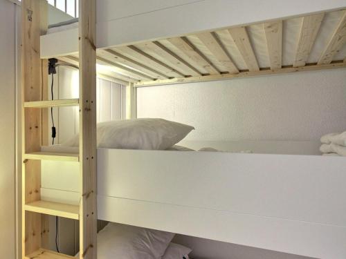 un lit superposé blanc dans une chambre avec un lit dans l'établissement Studio cabine rénové 5 pers, au pied des pistes, La Plagne - FR-1-455-256, à La Plagne Tarentaise