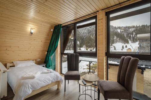 a bedroom with a bed and a large window at Rusca Retreat in Ruşca