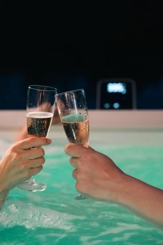 two people holding champagne glasses in a swimming pool at Aegean Serenity - Sea View Retreat in Archangelos