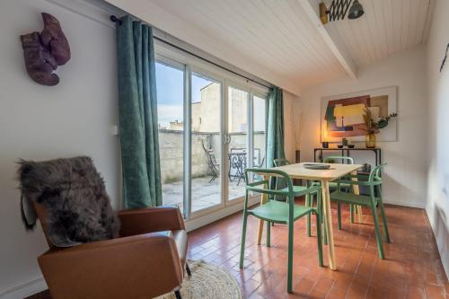 un salon avec une table et des chaises et une fenêtre dans l'établissement Appartement Limpero - Welkeys, à Avignon