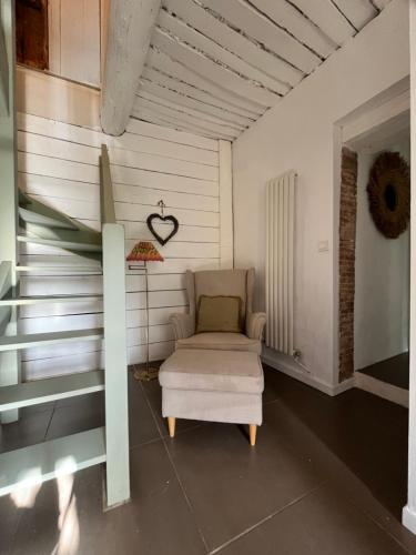 une chambre avec une chaise et un cœur sur le mur dans l'établissement La maison du Cours, à Rougiers