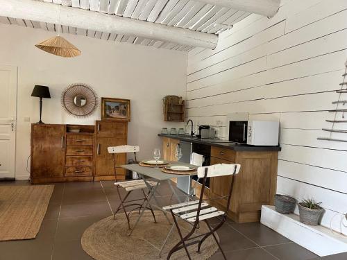 une cuisine avec une table et des chaises dans une pièce dans l'établissement La maison du Cours, à Rougiers