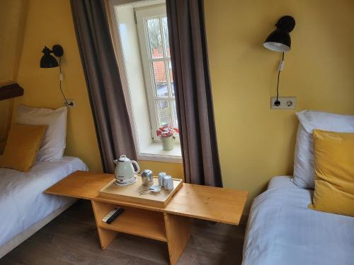 a room with a table and a bed and a window at Hotel Stedswal in Sloten