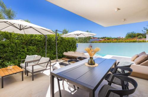 a patio with a table and chairs and a pool at Villa Adora for 6 people in Pula with private pool & children playground in Pula