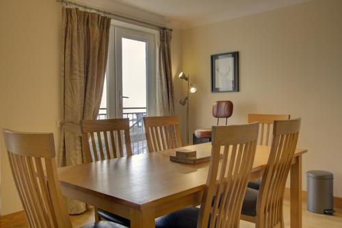 a dining room with a wooden table and chairs at No10 The Links Apartment, Brora in Brora