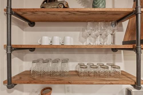 a wooden shelf with wine glasses on it at Rustic Charm Owasso Retreat in Owasso