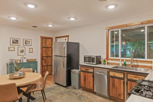 a kitchen with a table and a stainless steel refrigerator at Rustic Charm Owasso Retreat in Owasso