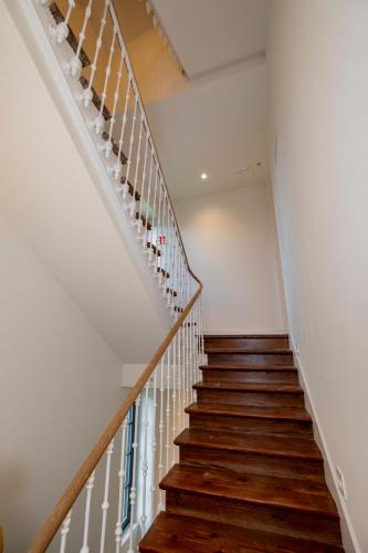 a staircase in a house with wooden floors and white walls at Indiano House Apartments, Muros de Nalón, 5km Cudillero in Muros de Nalón