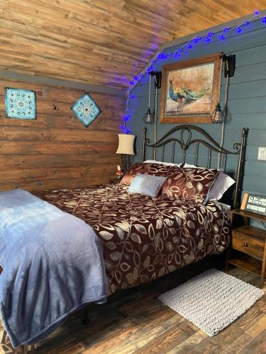 a bedroom with a bed and a wooden wall at Carlton Cabin at Lake of Egypt 500 Sq Ft in Goreville