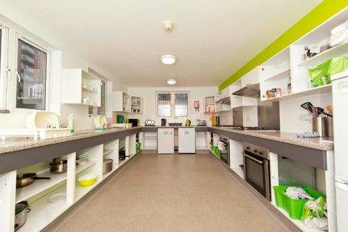 a large kitchen with white counters and white appliances at YHA Liverpool Albert Dock in Liverpool