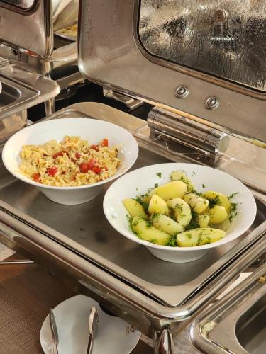 two bowls of food sitting on top of a stove at Dmall Hotel in Kigali