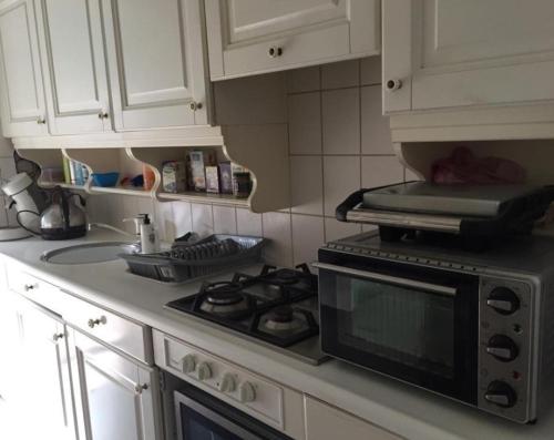 a kitchen with a stove and a microwave at De Deken in Best