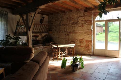 a living room with a couch and a table at Chambre d'Hôtes Le Moulin d'Encor in Seysses-Savès