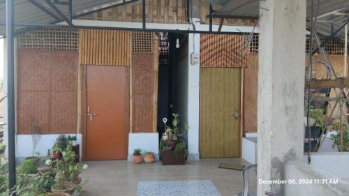 a row of doors in a building with plants at Amar Apun Ghor in Jorhāt