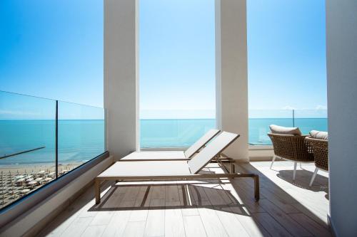 a balcony with a bench and a view of the ocean at Hotel Cavalieri Palace & Suites in Lido di Jesolo