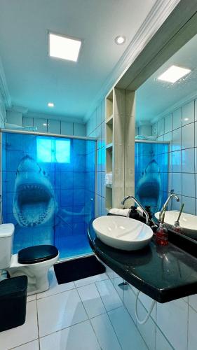 a blue bathroom with two sinks and a toilet at (308) Seaside - Sea View in São Luís