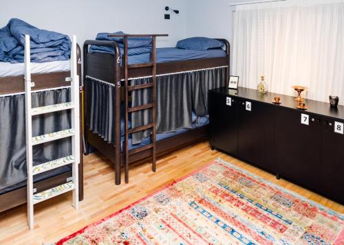 a room with two bunk beds and a rug at The Bearded Dad Hostel in Tirana