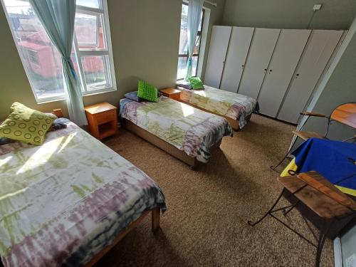 a room with two beds and a table and chairs at Oceanic Flashpackers accommodation in East London