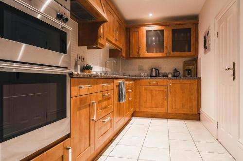a kitchen with wooden cabinets and a black appliance at Northumberland Lodge in Leamington Spa