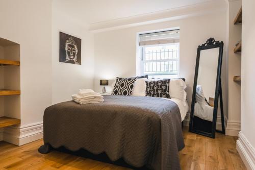 a bedroom with a bed and a mirror at Northumberland Lodge in Leamington Spa