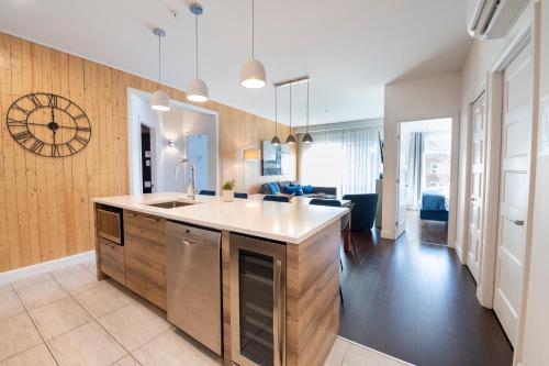 a kitchen with a sink and a living room at Saphir, Spacious 2-bedroom apartment, City center, Free parking in Quebec City