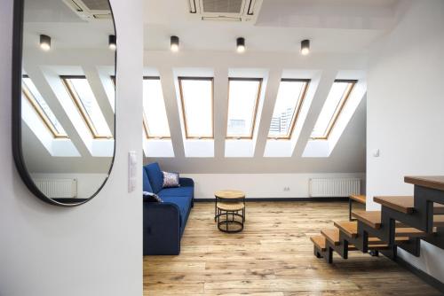 a living room with skylights and a blue couch at AboutArtApartments - By the river in Wrocław