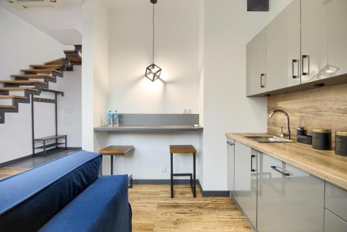 a kitchen with a blue couch and a stairway at AboutArtApartments - By the river in Wrocław