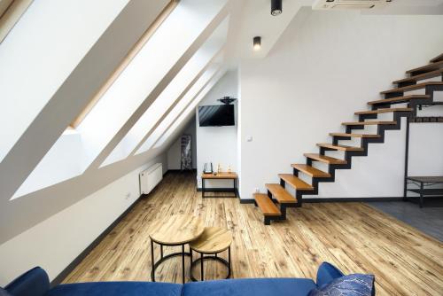 a living room with a blue couch and stairs at AboutArtApartments - By the river in Wrocław
