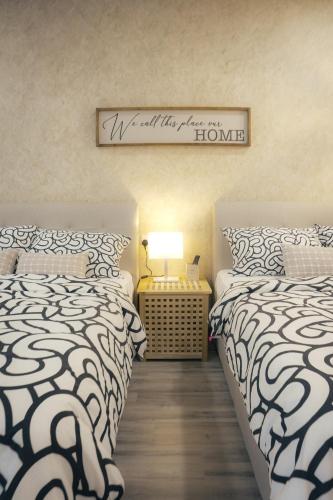 a bedroom with two beds and a sign on the wall at Suites Only KKB in Kuala Kubu Baharu