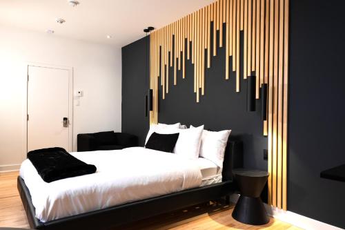 a bedroom with a large bed with a wall with acussioncussioncussioncussioncussion at #6 - Artistic Studio - Self Check in - Plateau - St-Denis - AC - TV in Montréal