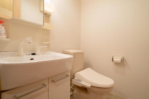 a white bathroom with a sink and a toilet at Belle Lead 105 in Tokyo