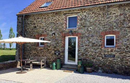 a stone building with a table and an umbrella at Pet Friendly Home In Villiers-Fossard in Villiers-Fossard