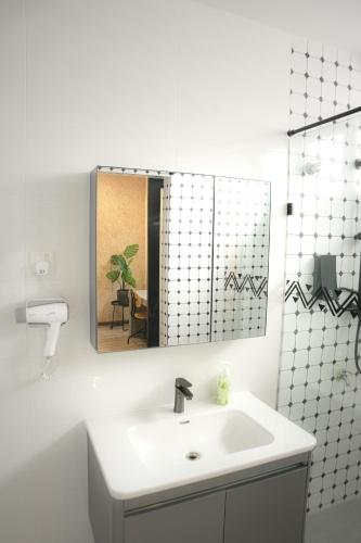 a white bathroom with a sink and a mirror at Suites Only KKB in Kuala Kubu Baharu